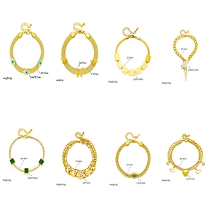 Golden chain bracelet collection with butterfly and evil eye charms on white background