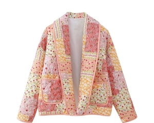 Detail of floral patchwork quilted jacket featuring intricate stitching and V-neckline