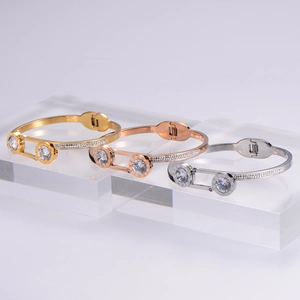 Detailed view of stacked Roman numeral bangles with zircon inlay in gold, silver, and rose gold