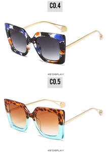 Detail view of oversized square sunglasses with gold metal temples and pearl tips
