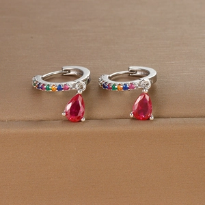 Macro shot of silver drop earrings with red teardrop gem and rainbow micro-pave crystals