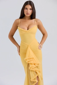 Detail of elegant yellow sundress showing delicate ruffle trim and sheer mesh fabric textures
