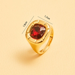 Detail shot of vintage gold-plated ring featuring a large red cushion-cut zircon stone