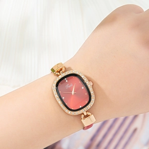 Nahaufnahme der Damenuhr mit roségoldener Strasslünette und rotem Lederarmband