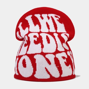 Detail of red Y2K knit beanie with white jacquard artistic font and thick texture