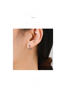 Detail shot of silver C-shape hoops with colorful enamel hearts on a female model