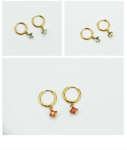 Detail of square zircon earrings in turquoise and orange-red on gold hoops
