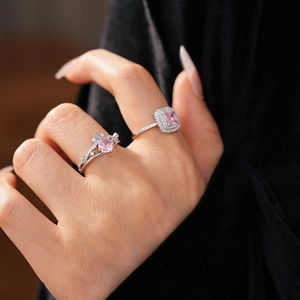 Detailed close-up of crown-shaped silver rings with pink square and round zircons