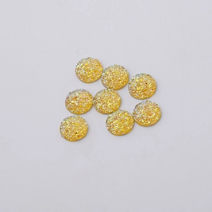 Detailed top view of 12mm yellow resin cabochons with gold glitter druzy texture