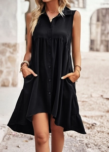 Détail de la robe noire sans manches avec bouton-pression, col et ourlet asymétrique