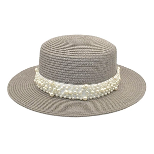 Détail d'un chapeau de paille gris à toit plat avec bandeau en perles blanches