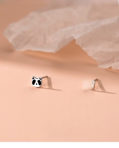 Makroaufnahme von S999 Sterlingsilber Panda-Ohrsteckern auf sanftem Pfirsichgrund