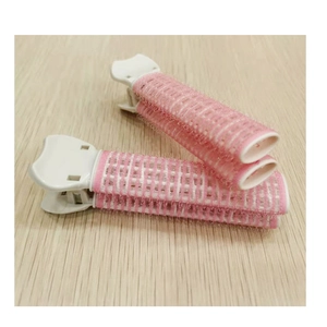Detailed close-up of pink and white mesh hair root volume clips on a wooden surface