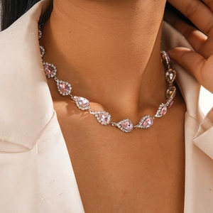 Gros plan du collier avec pendentif cristal rose en goutte et halo diamanté