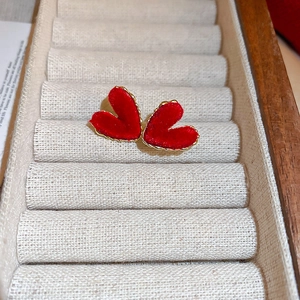 Élégantes boucles d'oreilles cœur floqué rouge et doré dans un coffret à bijoux de luxe