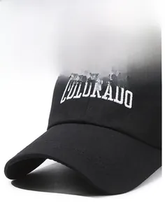 Detailed close-up of white COLORADO embroidery on a black cotton baseball cap surface