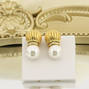 Close-up of vintage pearl earrings with gold ribbed metal and small crystal details