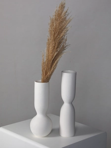 Close-up of modern white ceramic vases with detailed horizontal ribbed texture finish