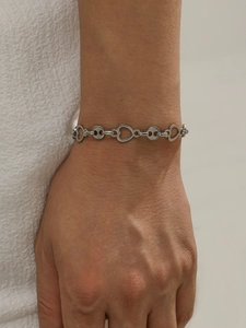Macro shot of silver stainless steel bracelet featuring heart and round link designs