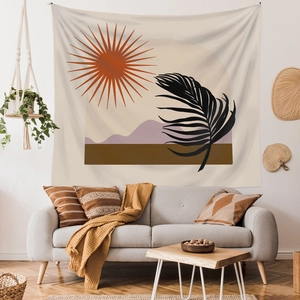 Détail d'une tapisserie bohème avec motif abstrait de soleil et montagne sur un canapé