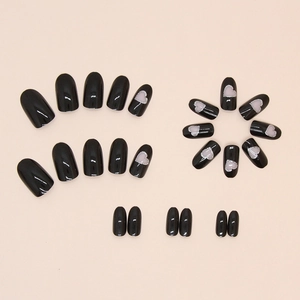 Black oval press-on nails with silver glitter hollow heart designs and pink accents
