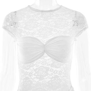 Close-up detail of white lace dress featuring intricate sheer embroidery and bandeau design