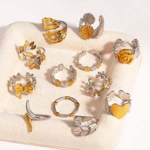 Detailed macro view of assorted two-tone gold and silver adjustable rings on jewelry tray