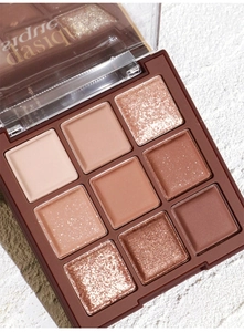 Macro shot of 9-color earthy eyeshadow palette with matte and shimmer textures