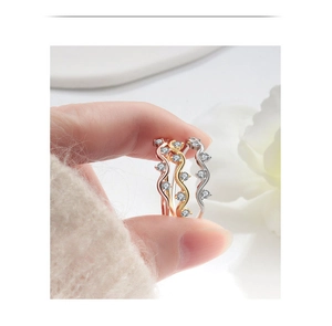 Detailed close-up of wavy zircon rings in rose gold, gold, and silver finishes
