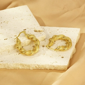 French vintage twisted gold hoop earrings in stainless steel on a textured stone base