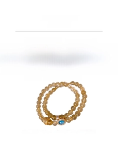Detail view of rutilated quartz beaded bracelet with gold-plated zircon and blue gemstone