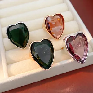 Elegant heart-shaped zircon rings in multiple colors displayed on a white velvet tray