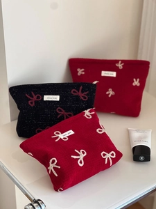 Detail of red and black cosmetic bags with ribbon embroidery and simple wish label
