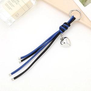 Detailed view of blue and black leather tassels with a silver heart-shaped metal pendant