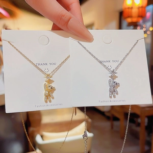Close-up of gold and silver bear pendant necklaces with star charms and sparkling stones
