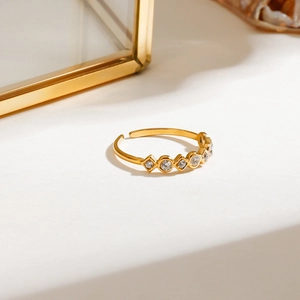 Close-up of adjustable gold ring featuring white round and square zircon stones