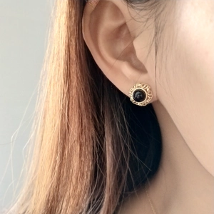 Detailed view of vintage 925 silver black onyx stud earring worn on ear for scale