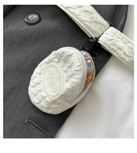 Close-up of white quilted mini coin purse with FASHION patch and black carabiner hook