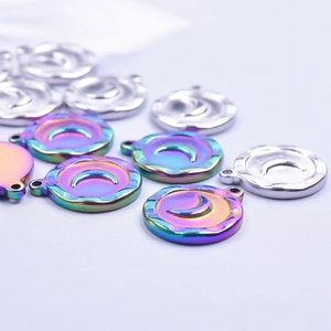 Macro shot of stainless steel moon and star charms with iridescent and silver finishes