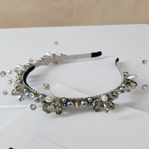 Detail of handmade luxury headband with grey crystals, pearls and gold wire accents