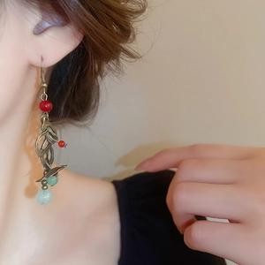 Détail rapproché de boucles d'oreilles à pompons rétro avec perles sur un mannequin