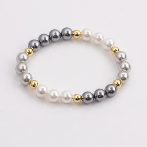 Elegant beaded bracelet featuring gradient faux pearls and polished gold beads on white background