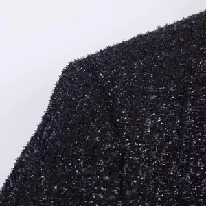 Close-up of black tweed fabric featuring sparkling silver metallic thread and texture