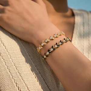 Luxurious gold leaf bracelets with white and black marquise zircon stones on model wrist