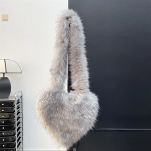 Detail of grey heart-shaped faux fur crossbody bag with soft long plush texture