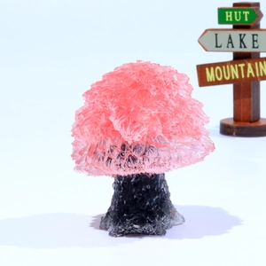 Detailed close-up of handmade pink crystal resin tree with dark natural stone base
