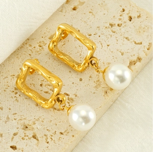 Detail of vintage gold hammered rectangular earrings with lustrous white pearls