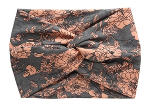 Detail of wide twisted headband with orange floral patterns on dark grey fabric