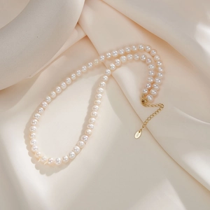 Detail of elegant natural freshwater pearl necklace with S925 silver clasp on silk
