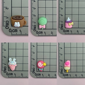 Detailed size measurement of mini resin stars and candy charms using a centimeter ruler